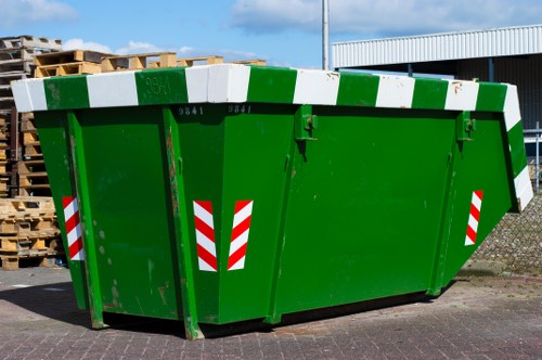 Skip hire truck outside a Wanstead street with recycling bins